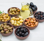 assorted-variety-olives-clay-bowls-with-olive-leaves-jar-olive-oil-high-angle-view-white-wood 1